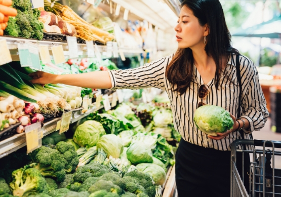 Woman selecting vegetables in grocery store
